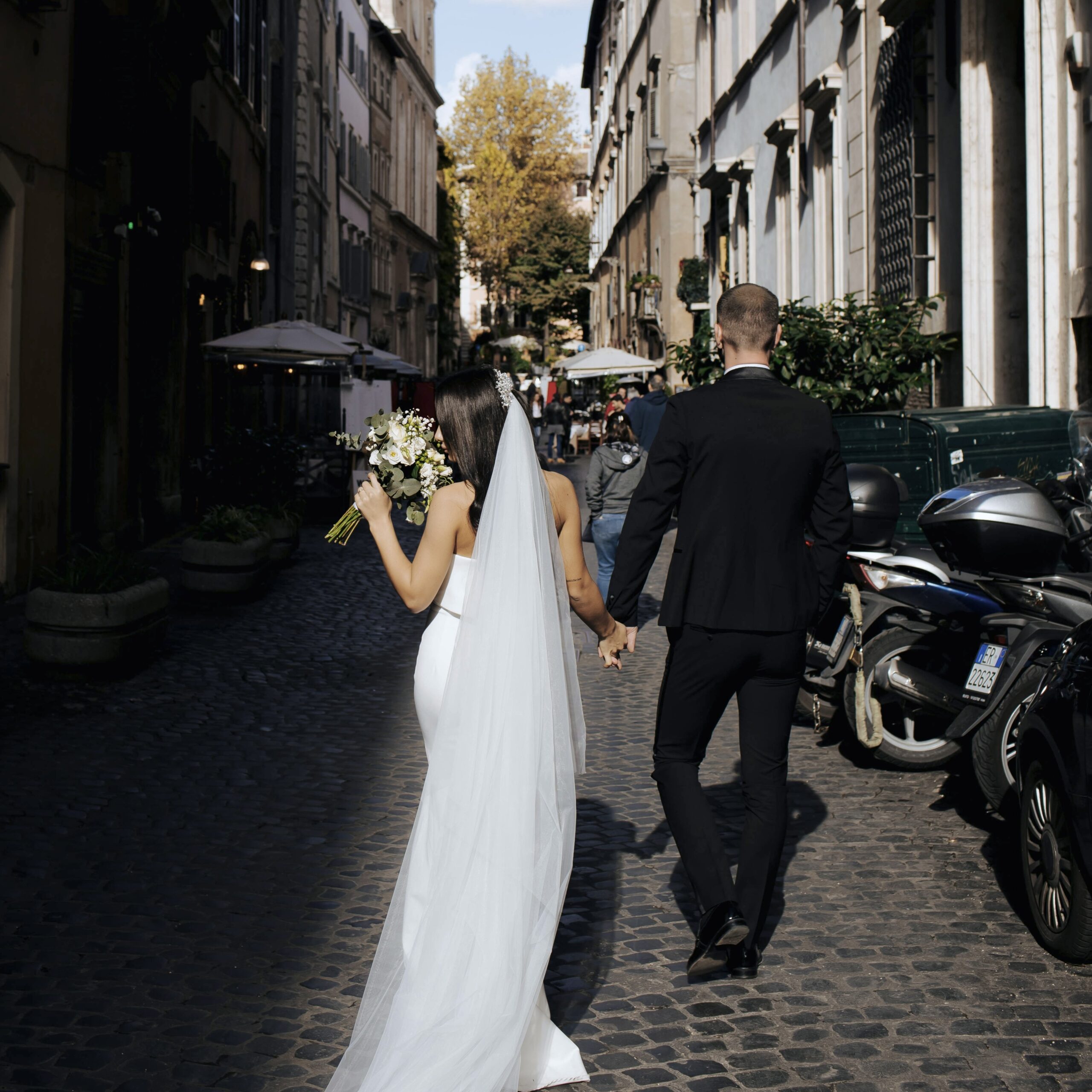 A couple walking on a beautiful street after getting married A couple walking on a beautiful street after getting married